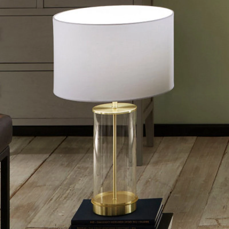 Image of Pacific Lifestyle Clear Glass And Champagne Metal Table Lamp With Ivory Poly Cotton Cylinder Drum Shade