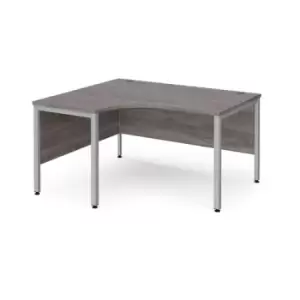 Image of Maestro 25 left hand ergonomic desk 1400mm wide - silver bench leg frame and grey oak top